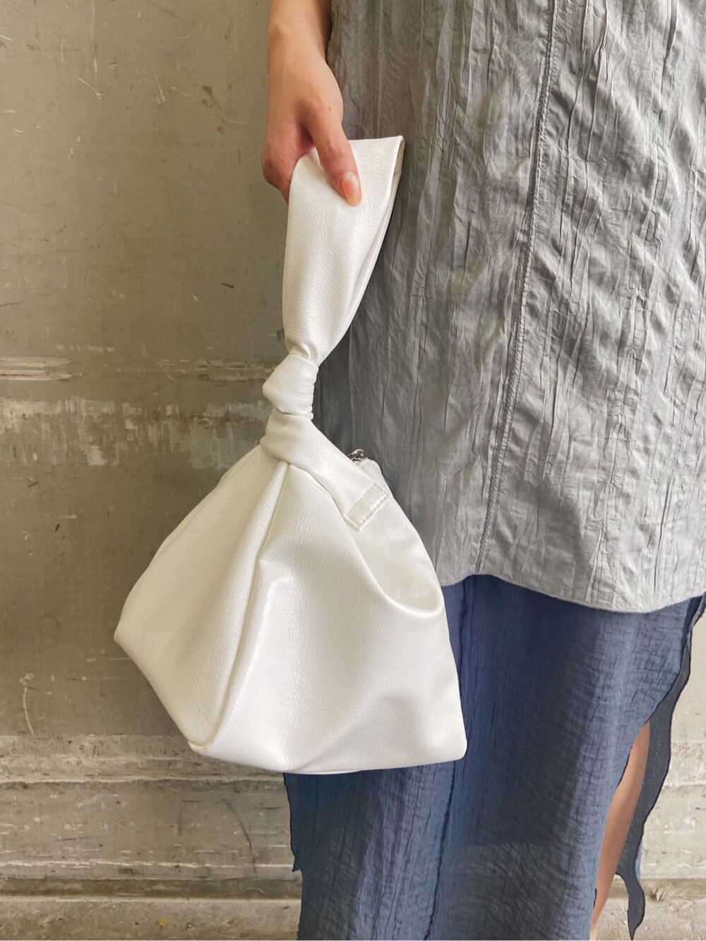 グレー系のワンピース、ホワイト系のサンダル、ホワイト系のハンドバッグを着用したレディースの夏コーディネートの6枚目の写真