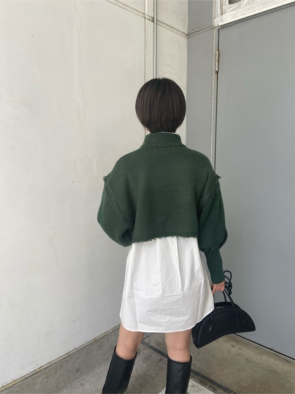 ブラック系のスカート、ブラック系のブーツ、ホワイト系のシャツ/ブラウスを着用したレディースの秋コーディネートの4枚目の写真