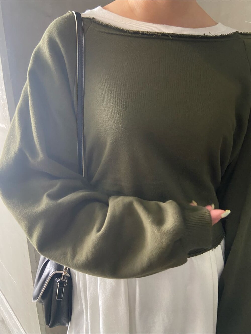 グレー系のスカート、ブラック系のショルダーバッグ、ホワイト系のTシャツ/カットソーを着用したレディースの秋コーディネートの7枚目の写真