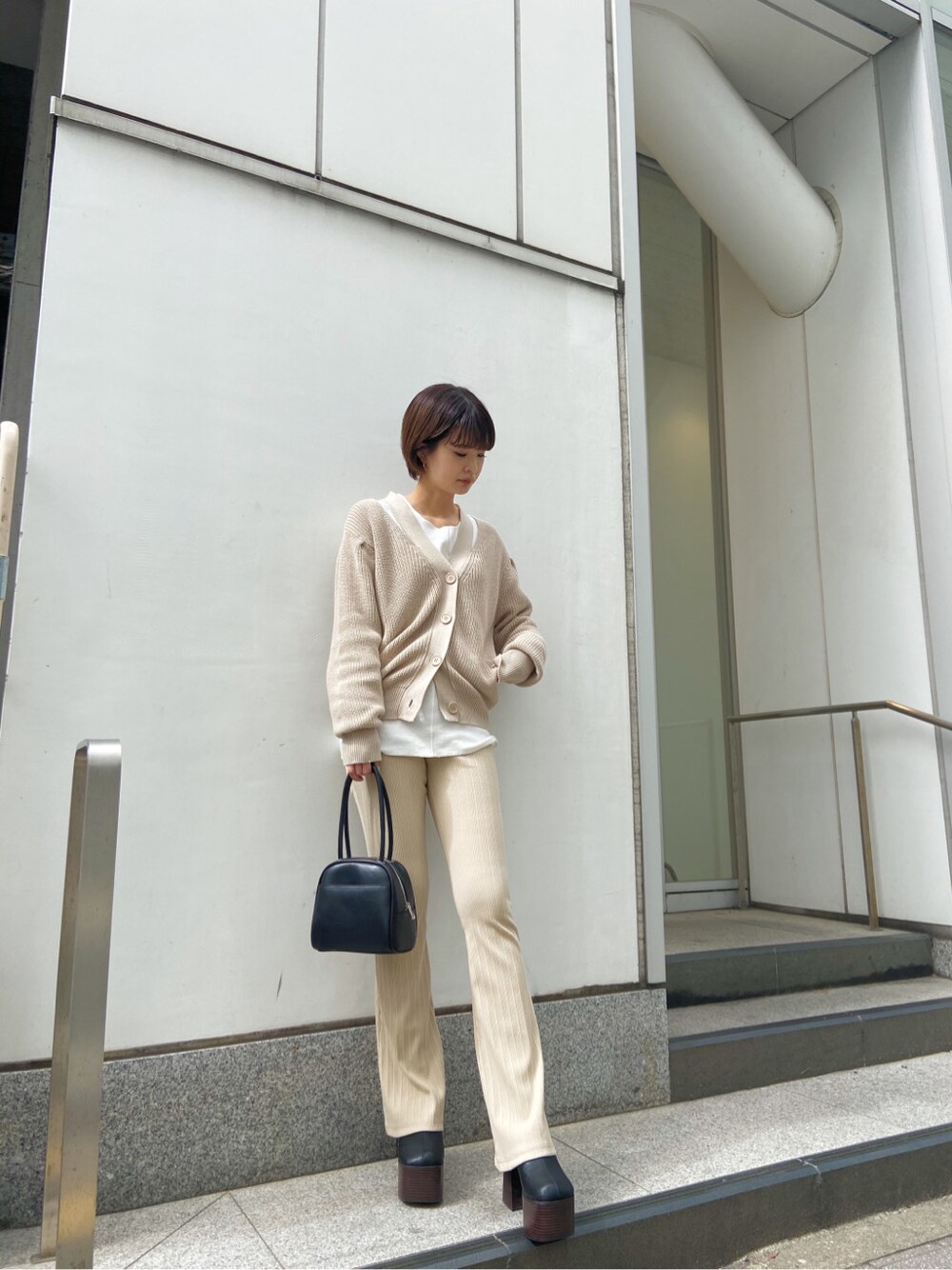 ベージュ系のその他パンツ、ブラック系のサンダル、ブラック系のハンドバッグを着用したレディースの春コーディネートの2枚目の写真