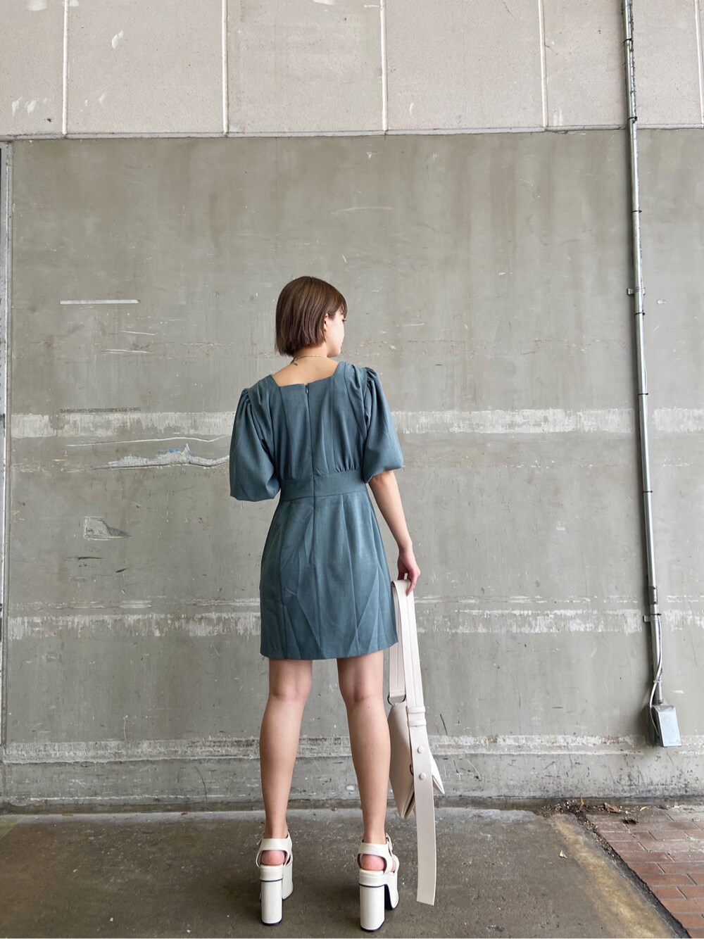 ホワイト系のショルダーバッグ、グリーン系のワンピース、ホワイト系のサンダルを着用したレディースの春コーディネートの3枚目の写真