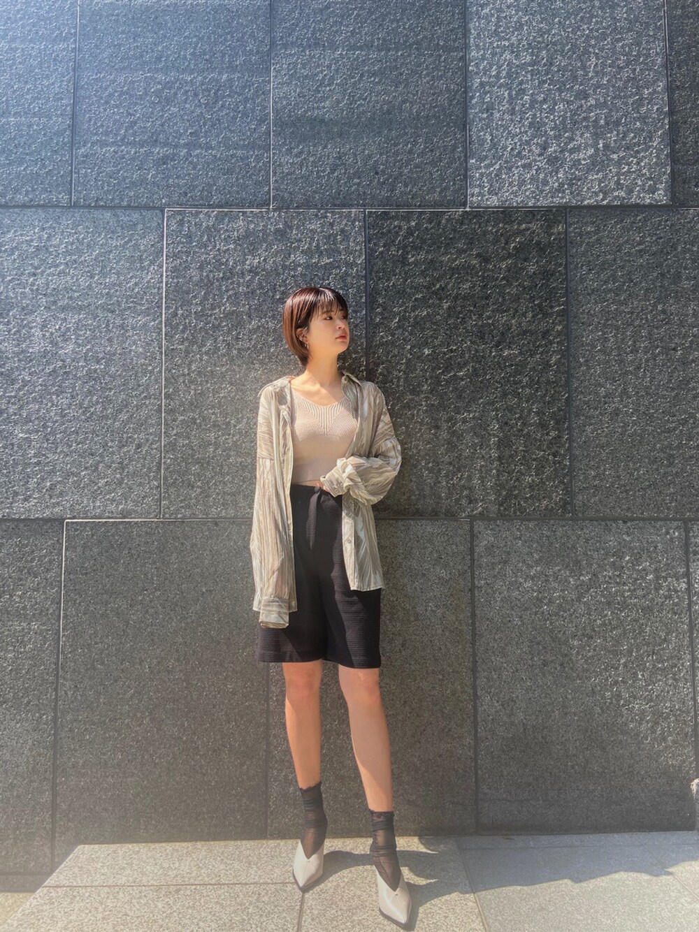ブラック系のその他パンツ、ホワイト系のサンダル、ベージュ系のシャツ/ブラウスを着用したレディースの春コーディネートの3枚目の写真