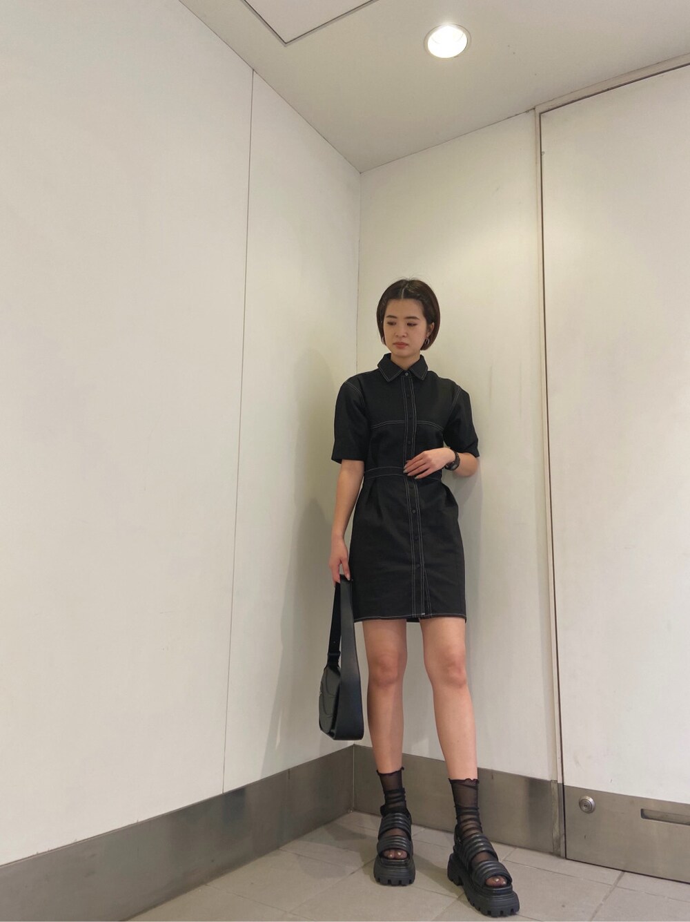 ブラック系のワンピース、ブラック系のサンダル、ブラック系のショルダーバッグを着用したレディースの春コーディネートの2枚目の写真