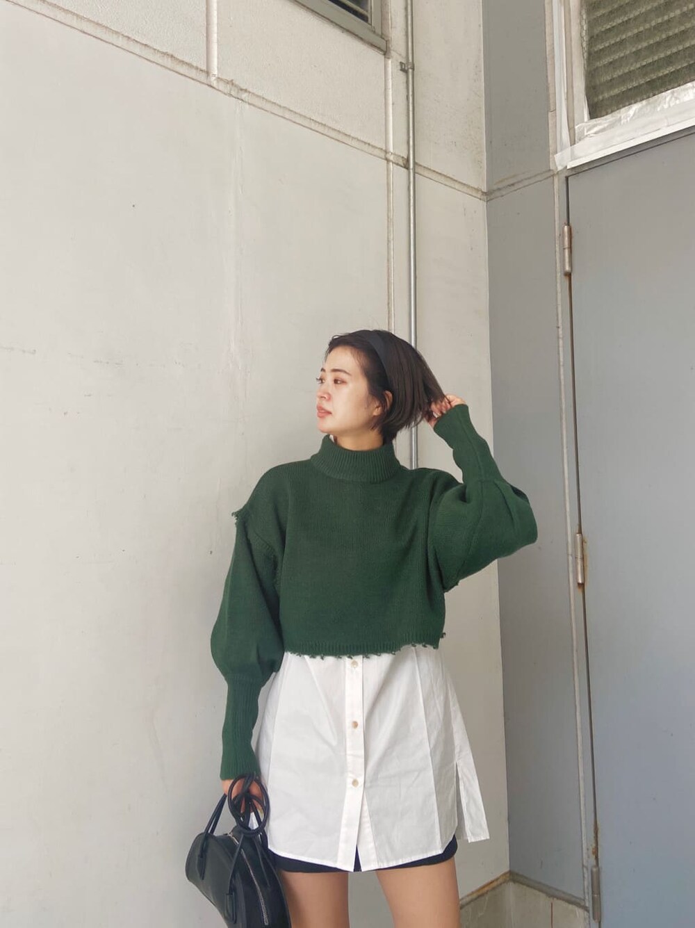 ブラック系のスカート、ブラック系のブーツ、ホワイト系のシャツ/ブラウスを着用したレディースの秋コーディネートの3枚目の写真