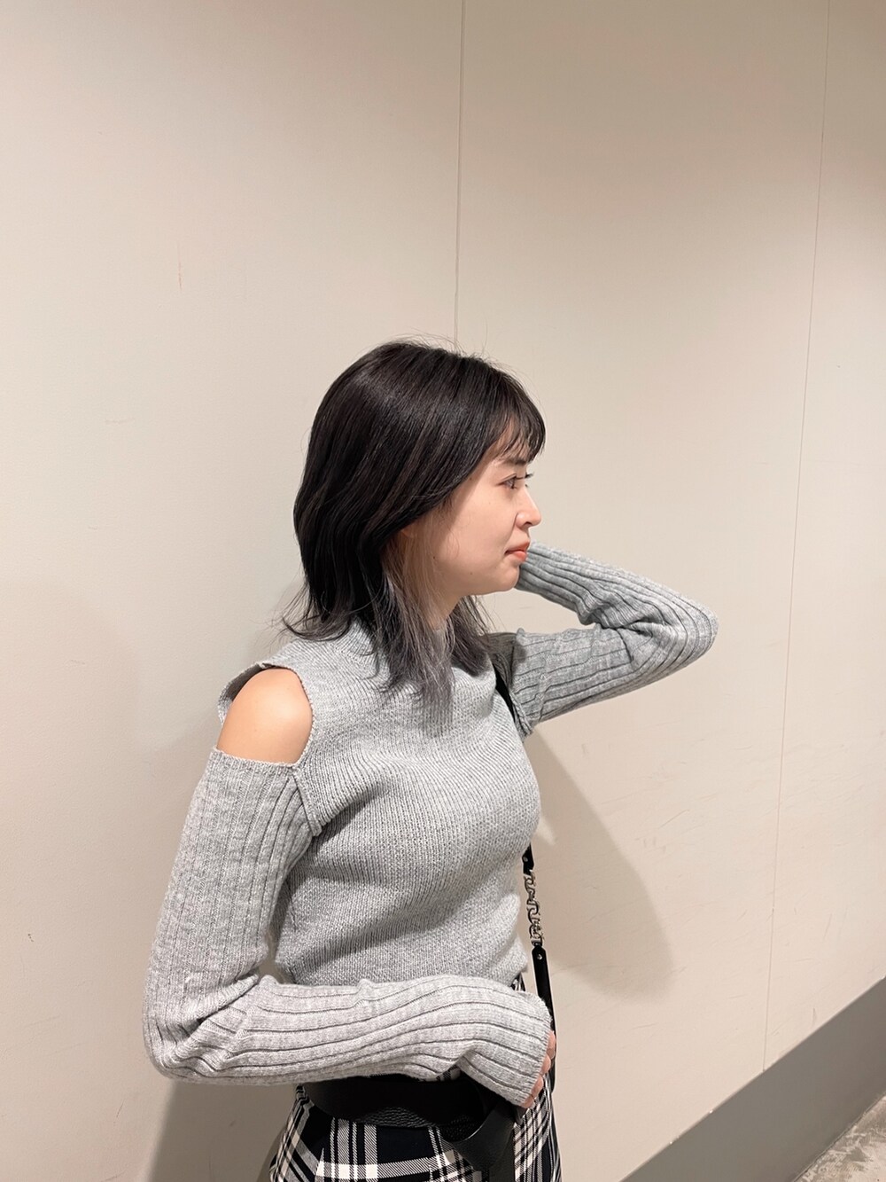 ブラック系のブーツ、グレー系のニット/セーター、ブラック系のスカートを着用したレディースの冬コーディネートの3枚目の写真