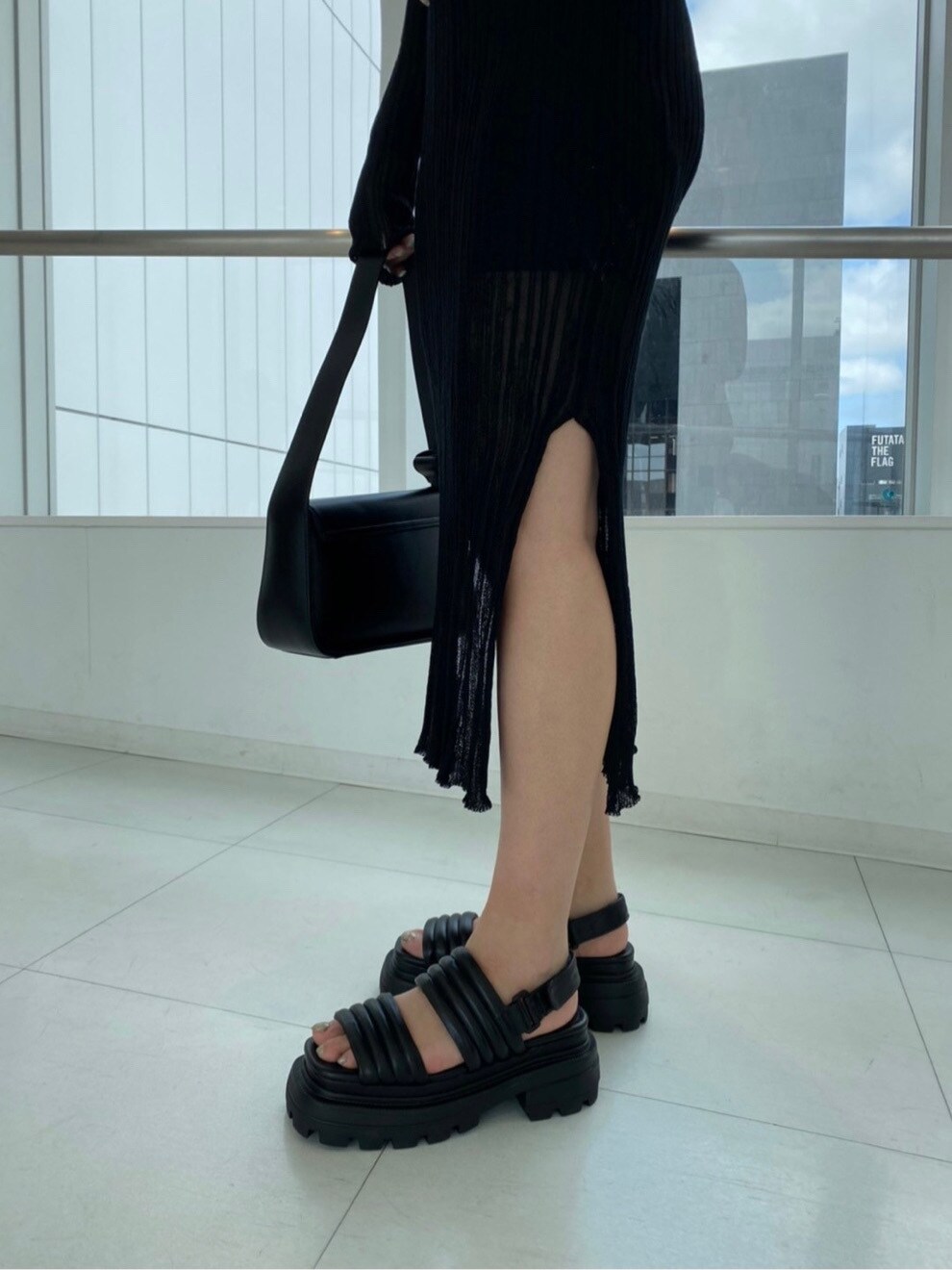 ブラック系のサンダル、ブラック系のショルダーバッグ、ブラック系のワンピースを着用したレディースの春コーディネートの4枚目の写真