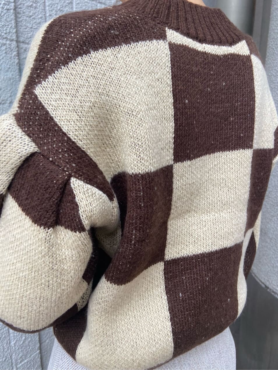 ホワイト系のスカート、ベージュ系のハンドバッグ、ブラウン系のカーディガン/ボレロを着用したレディースの冬コーディネートの5枚目の写真