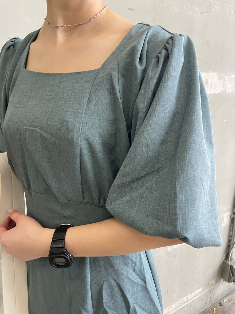 ホワイト系のショルダーバッグ、グリーン系のワンピース、ホワイト系のサンダルを着用したレディースの春コーディネートの2枚目の写真