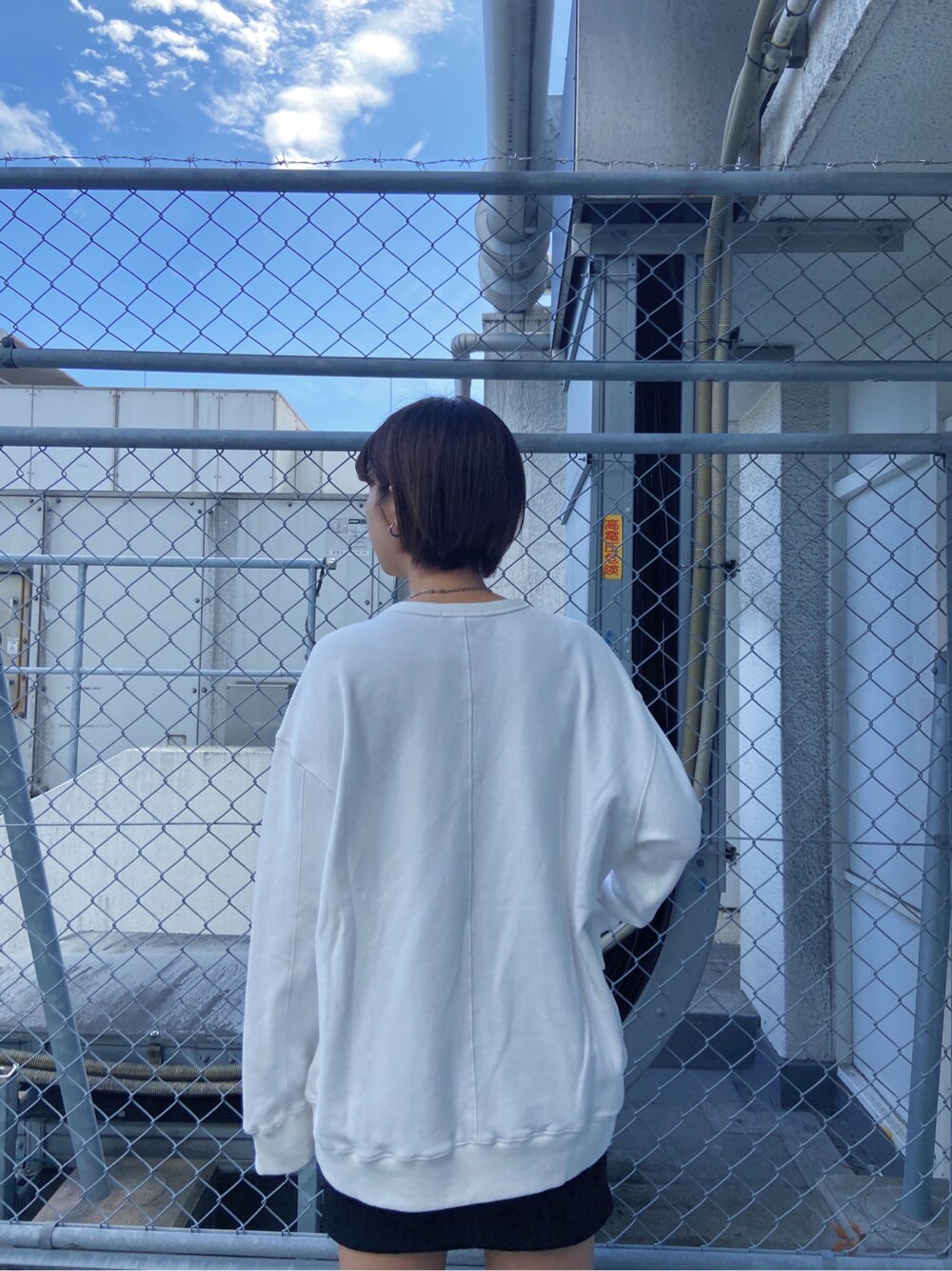 ブラック系のテーラードジャケット、ブラック系のサンダル、ホワイト系のスウェットを着用したレディースの春コーディネートの4枚目の写真