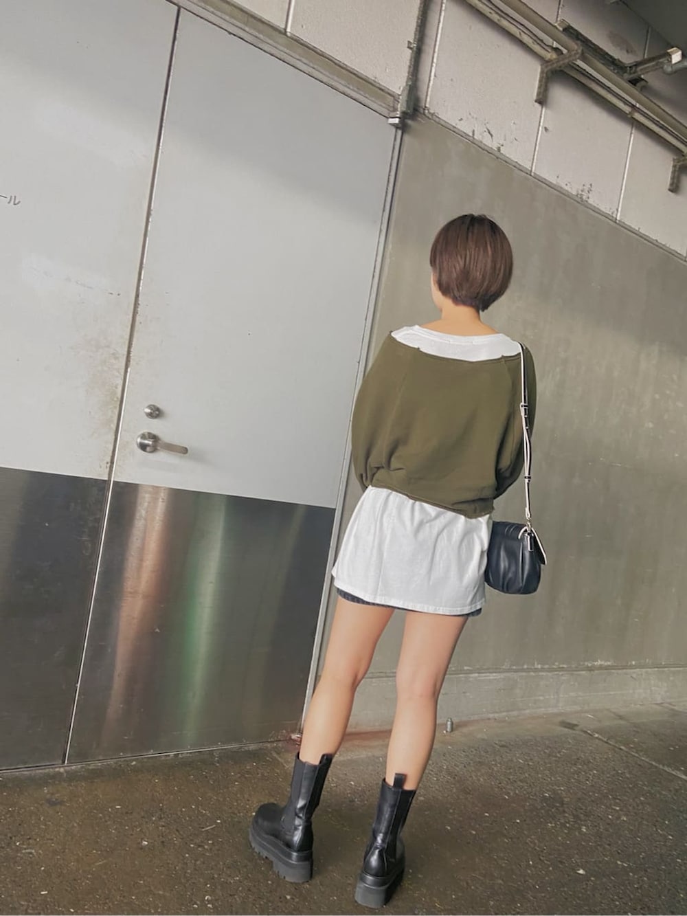 グレー系のスカート、ブラック系のショルダーバッグ、ホワイト系のTシャツ/カットソーを着用したレディースの秋コーディネートの5枚目の写真