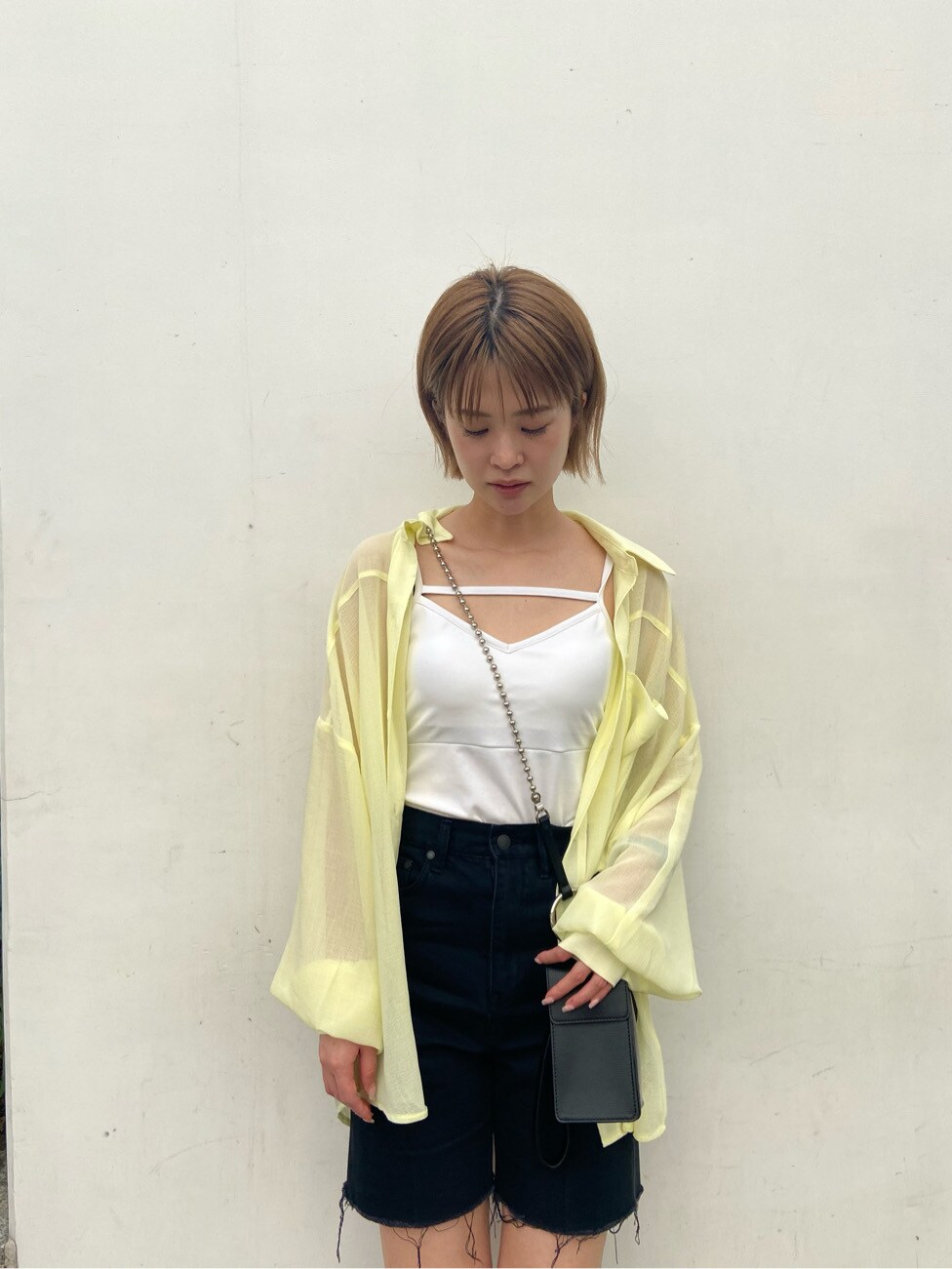 イエロー系のシャツ/ブラウス、ブラック系のサンダル、ブラック系のデニムパンツを着用したレディースの夏コーディネートの5枚目の写真