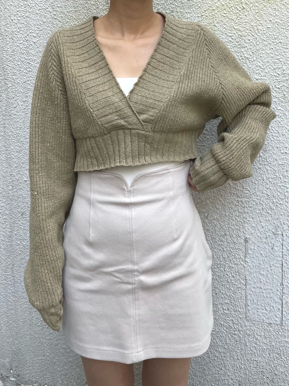 ホワイト系のスカート、ホワイト系のキャミソール、ベージュ系のワンピースを着用したレディースの冬コーディネートの3枚目の写真