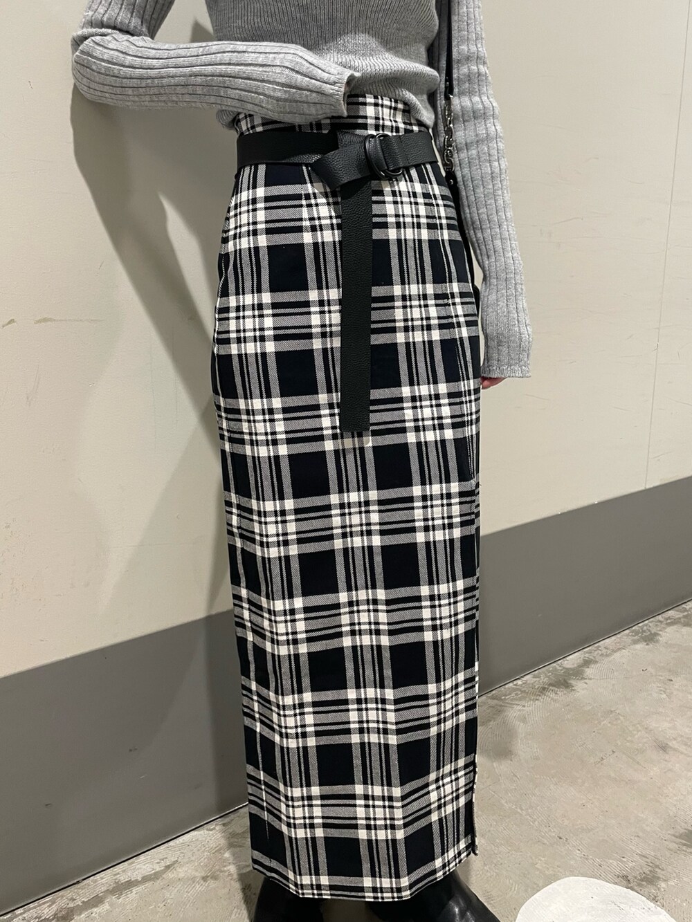 ブラック系のブーツ、グレー系のニット/セーター、ブラック系のスカートを着用したレディースの冬コーディネートの5枚目の写真