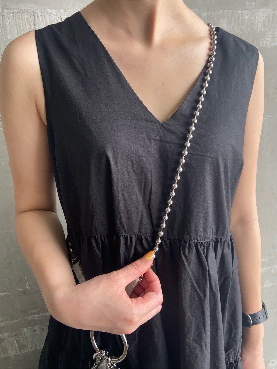 ブラック系のサンダル、ホワイト系のショルダーバッグ、ブラック系のワンピースを着用したレディースの夏コーディネートの4枚目の写真