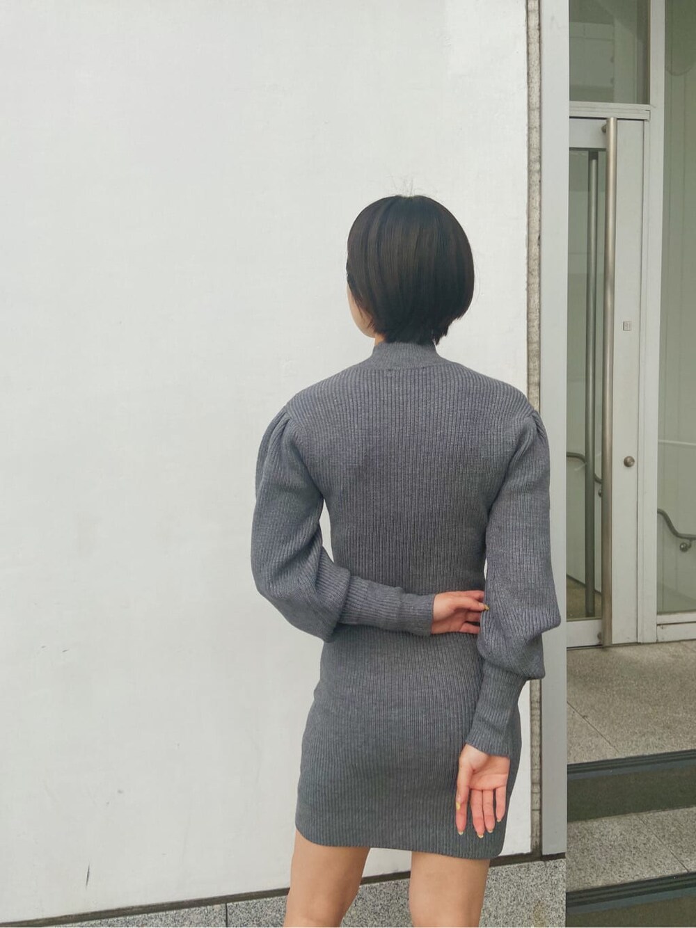 ホワイト系のブルゾン、グレー系のワンピースを着用したレディースの秋コーディネートの5枚目の写真