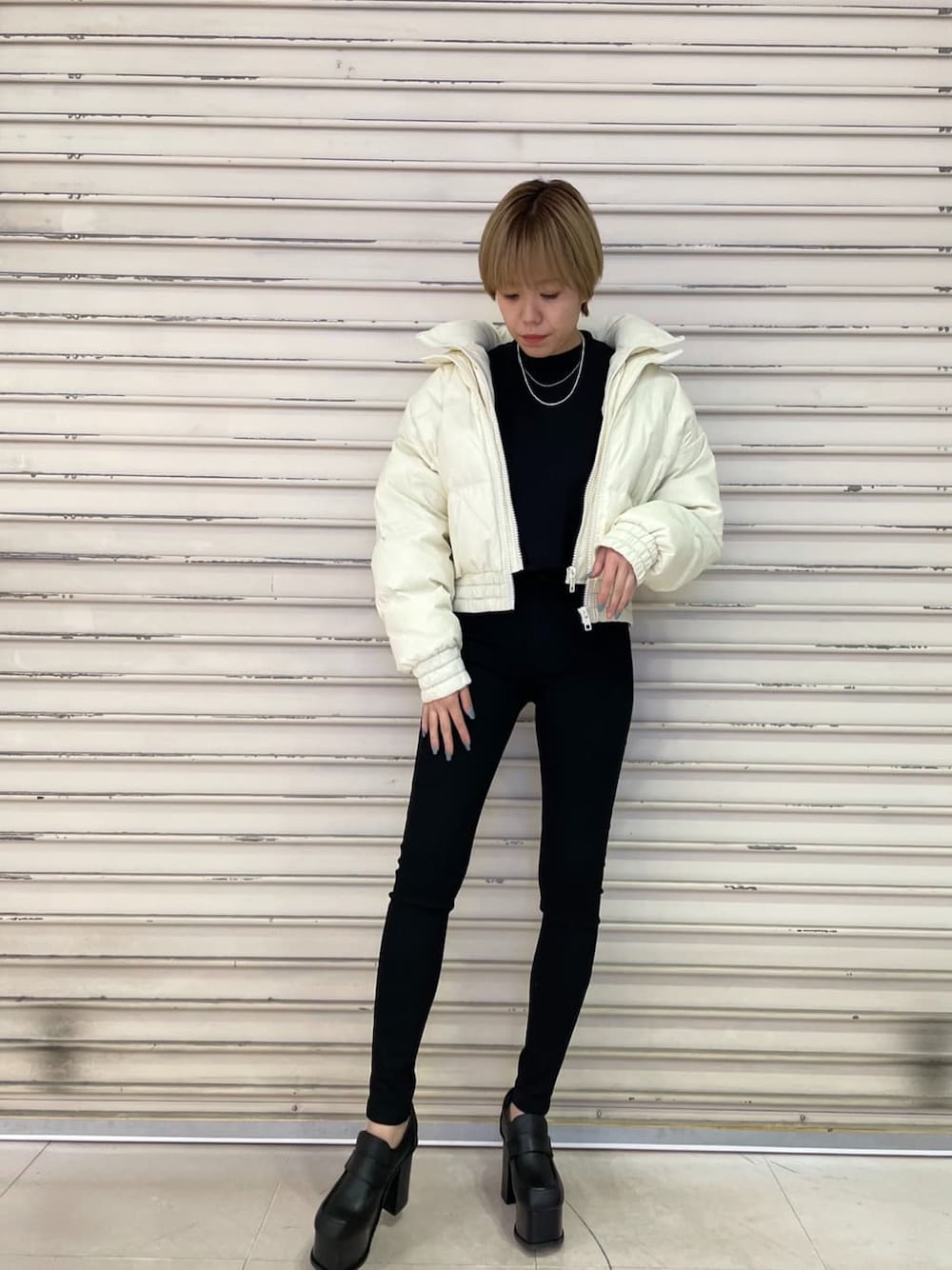 ブラック系のTシャツ/カットソー、ブラック系のデニムパンツ、ブラック系のローファーを着用したレディースの冬コーディネートの2枚目の写真