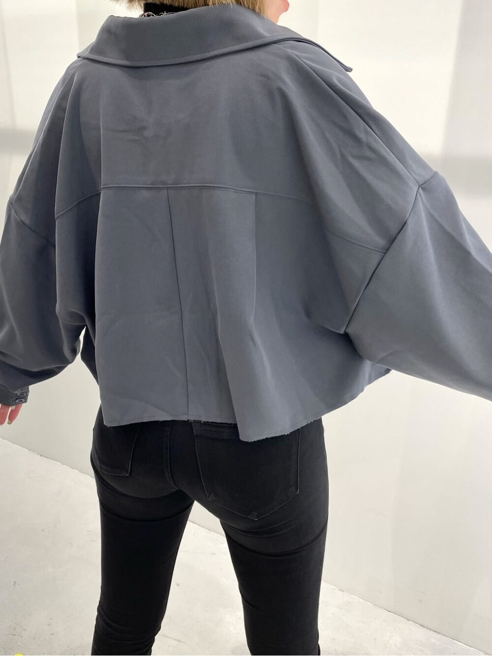 ブルー系のテーラードジャケット、ブラック系のブーツ、ブラック系のデニムパンツを着用したレディースの夏コーディネートの5枚目の写真