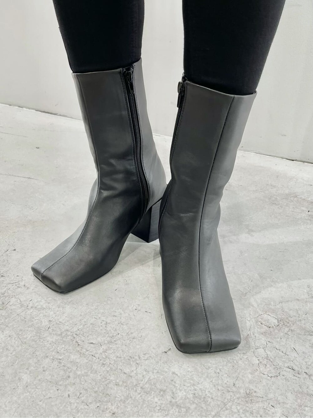 ブルー系のテーラードジャケット、ブラック系のブーツ、ブラック系のデニムパンツを着用したレディースの夏コーディネートの7枚目の写真