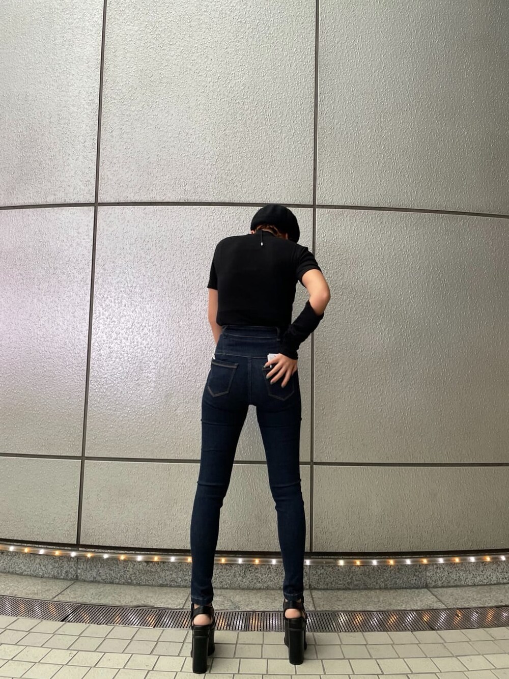 ブルー系のデニムパンツ、ブラック系のサンダル、ブラック系のTシャツ/カットソーを着用したレディースの夏コーディネートの4枚目の写真