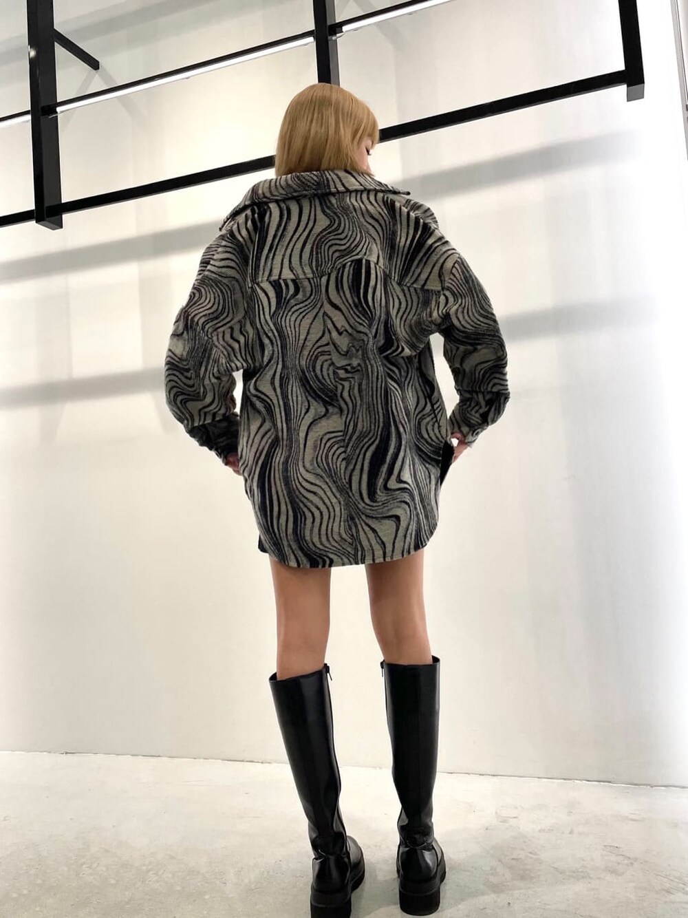 ブラック系のワンピース、その他のブルゾン、ブラック系のブーツを着用したレディースの秋コーディネートの4枚目の写真