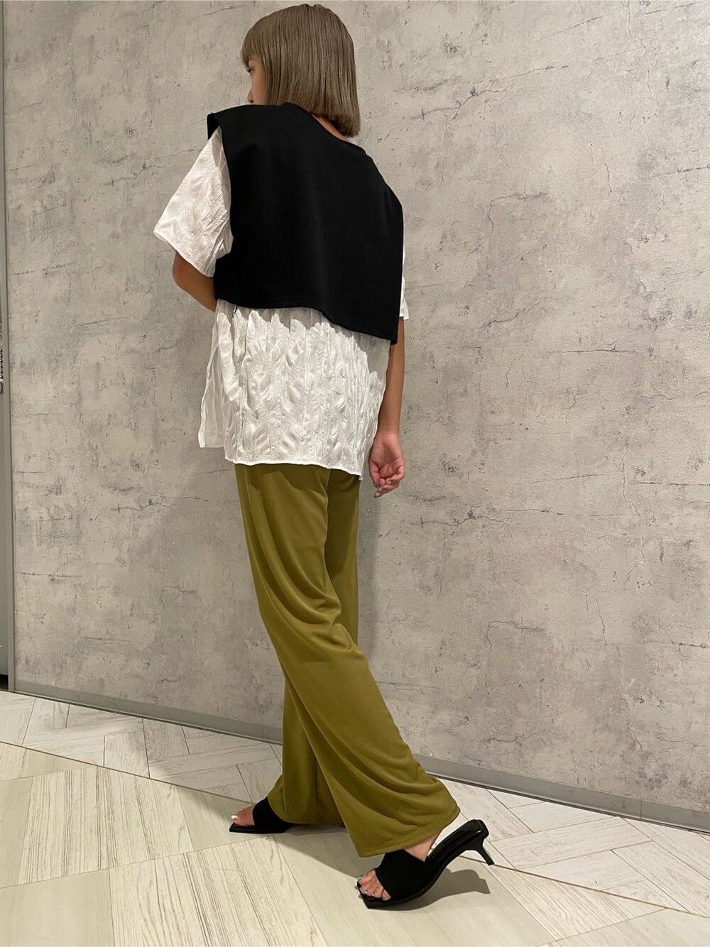 イエロー系のその他パンツ、ブラック系のサンダル、ブラック系のTシャツ/カットソーを着用したレディースの夏コーディネートの3枚目の写真