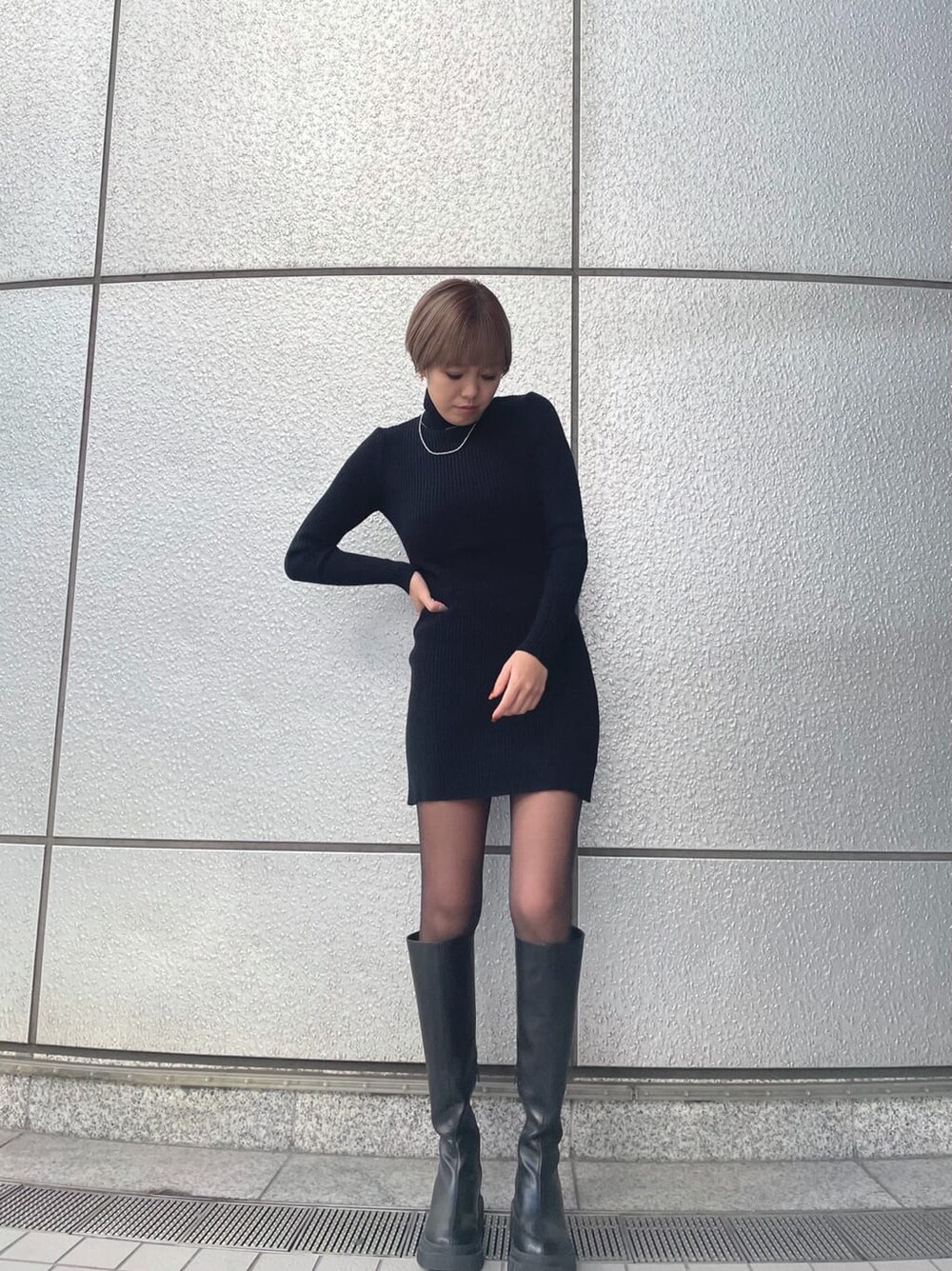 ブラック系のワンピース、その他のムートンコート、ブラック系のブーツを着用したレディースの冬コーディネートの5枚目の写真