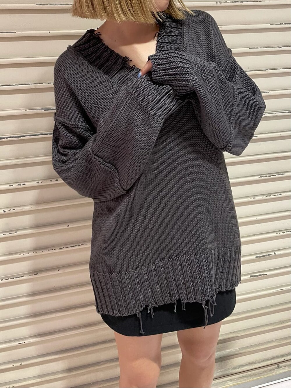 ブラック系のスカート、グレー系のニット/セーターを着用したレディースの秋コーディネートの6枚目の写真