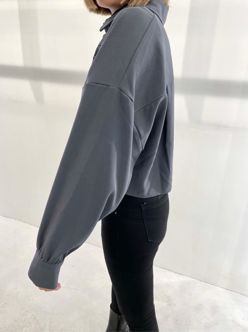 ブルー系のテーラードジャケット、ブラック系のブーツ、ブラック系のデニムパンツを着用したレディースの夏コーディネートの4枚目の写真