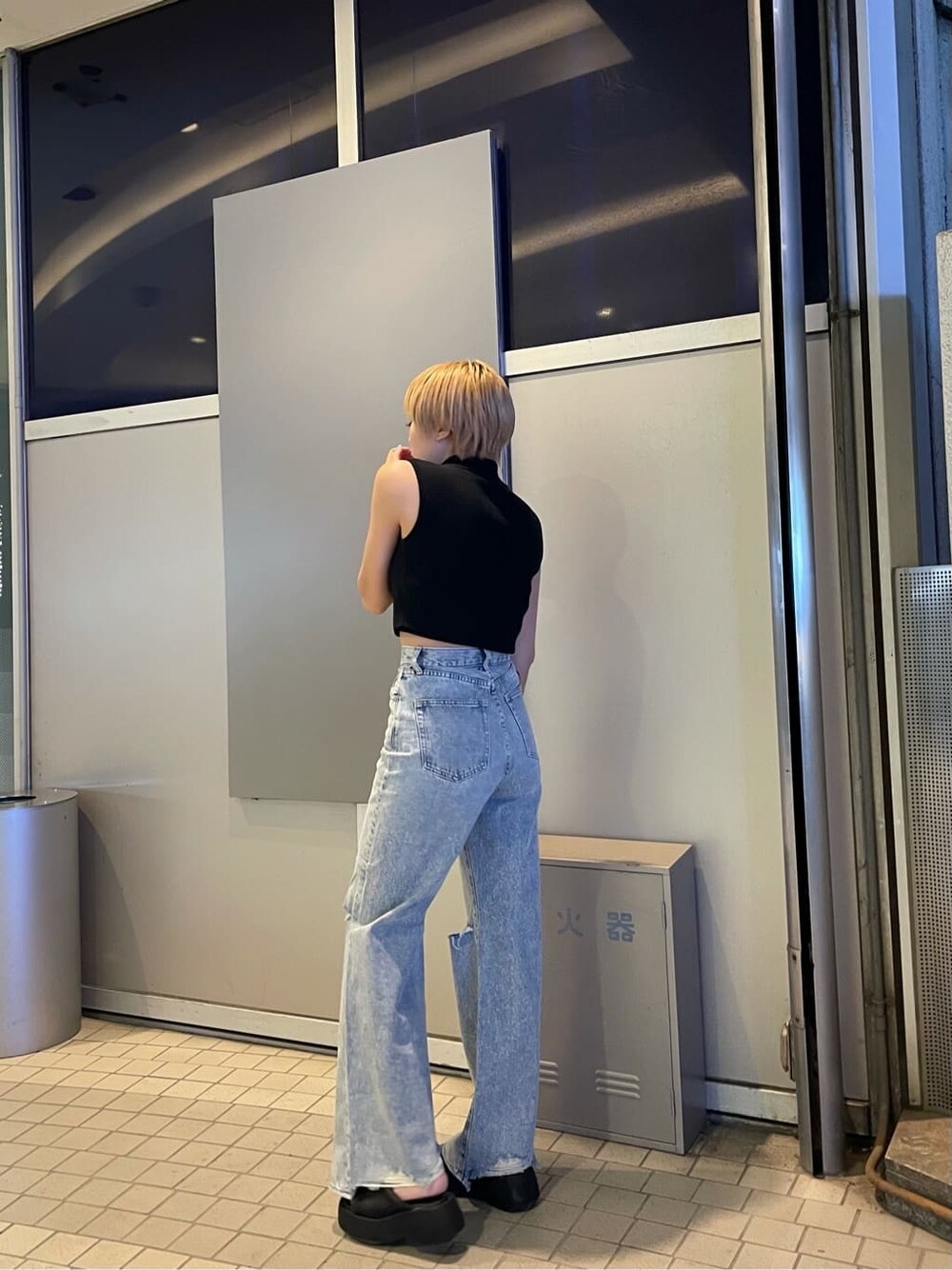 ブラック系のサンダル、ブルー系のデニムパンツ、ブラック系のタンクトップを着用したレディースの夏コーディネートの2枚目の写真