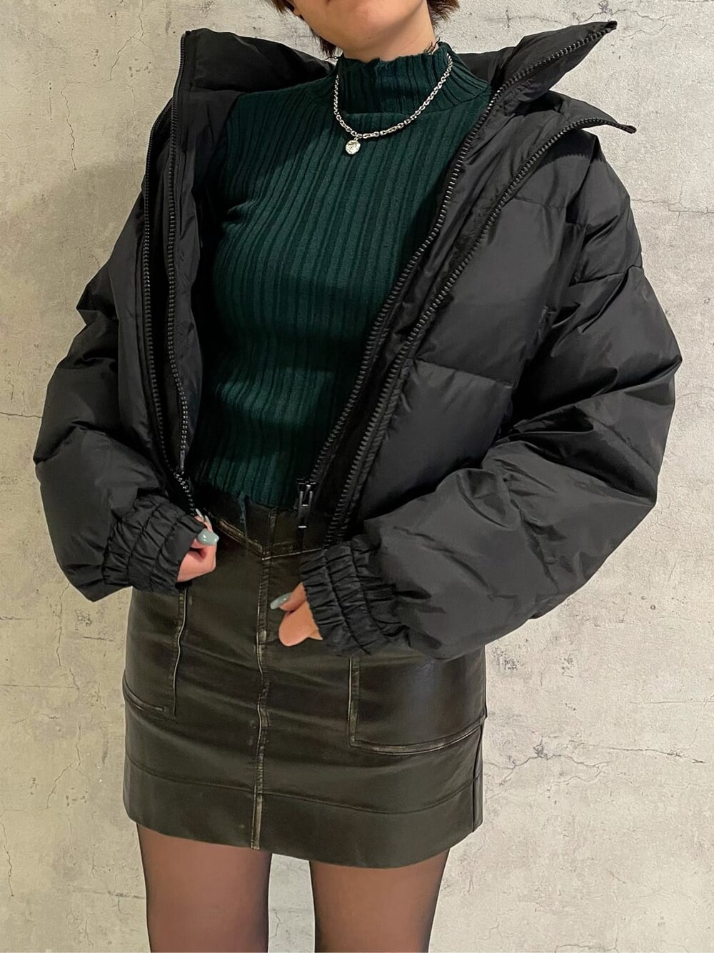 ブラック系のブーツ、ブラック系のスカート、ブラック系のダウンジャケット/コートを着用したレディースの冬コーディネートの6枚目の写真