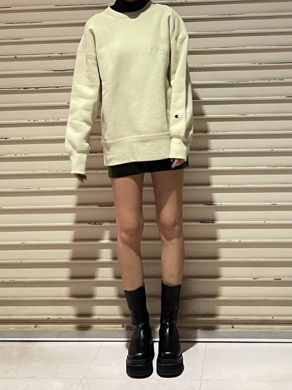 ベージュ系のスウェット、ブラック系のスカートを着用したレディースの冬コーディネートの3枚目の写真