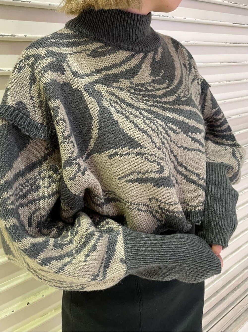 ブラック系のスカート、ブラック系のブーツ、その他のニット/セーターを着用したレディースの秋コーディネートの6枚目の写真