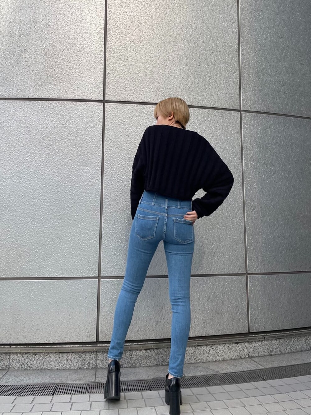 ブラック系のニット/セーター、ブラック系のローファー、ブルー系のデニムパンツを着用したレディースの冬コーディネートの3枚目の写真