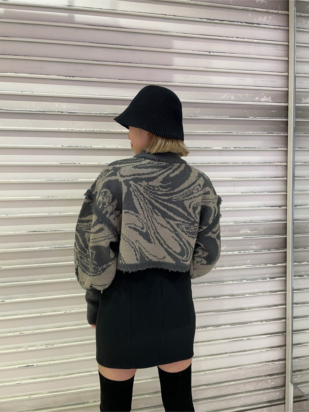 ブラック系のスカート、ブラック系のブーツ、その他のニット/セーターを着用したレディースの秋コーディネートの5枚目の写真