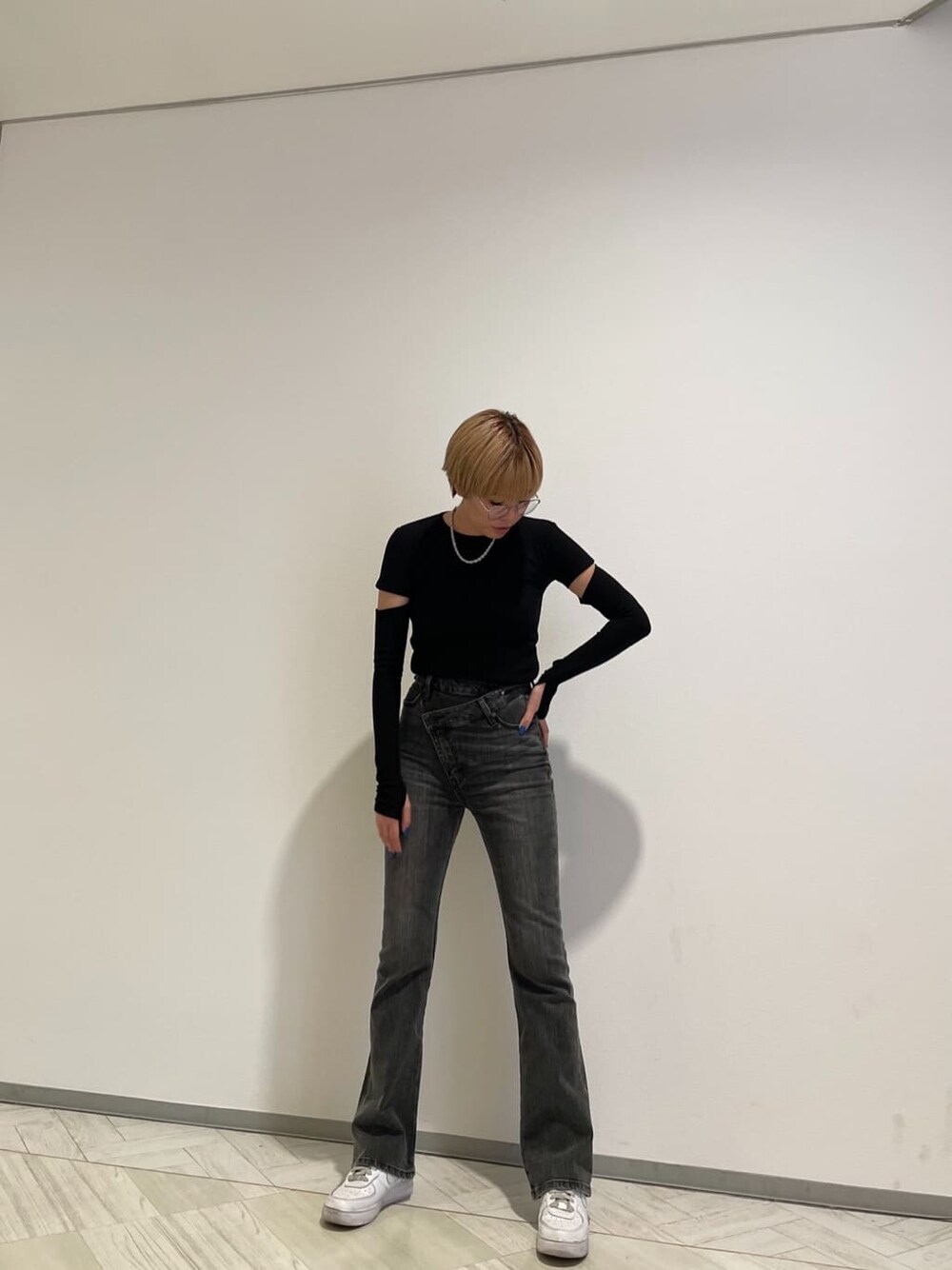 グレー系のデニムパンツ、ブラック系のTシャツ/カットソー、ブラック系のメガネを着用したレディースの春コーディネートの2枚目の写真