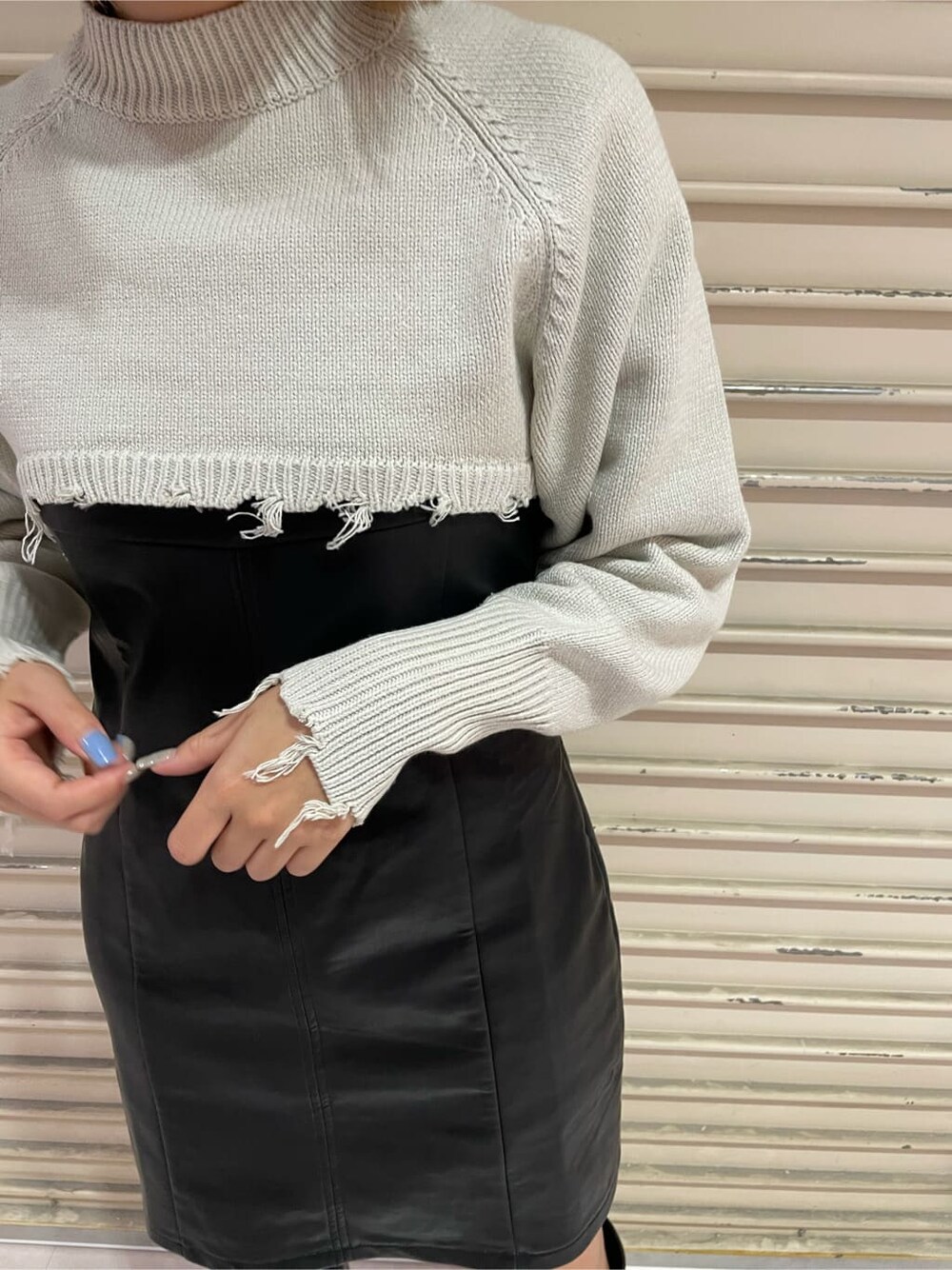 ブラック系のワンピース、ブラック系のブーツ、ホワイト系のニット/セーターを着用したレディースの秋コーディネートの5枚目の写真