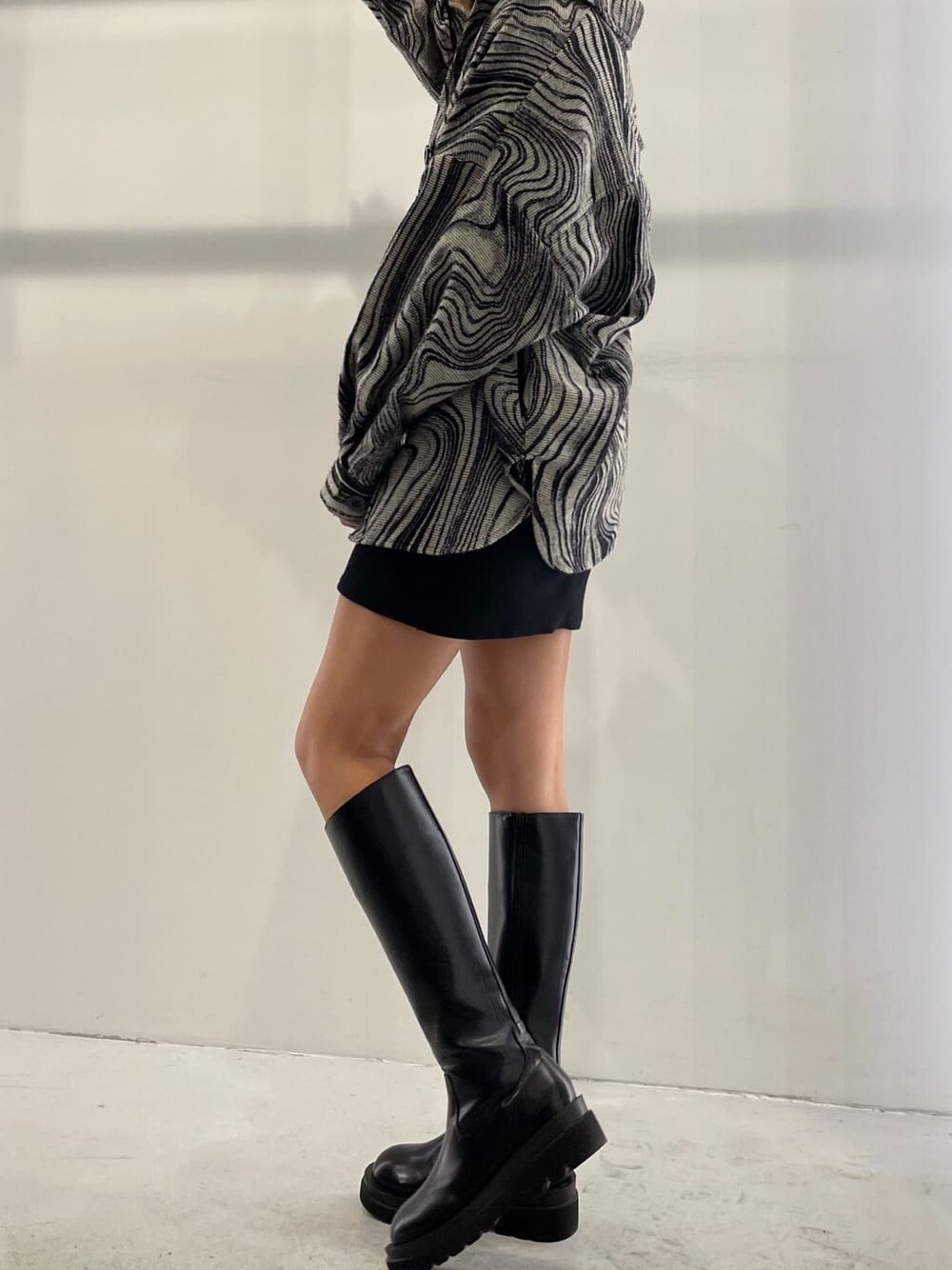 ブラック系のワンピース、その他のブルゾン、ブラック系のブーツを着用したレディースの秋コーディネートの2枚目の写真