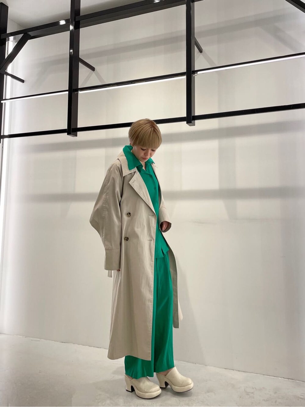 グリーン系のシャツ/ブラウス、グリーン系のその他パンツ、ベージュ系のトレンチコートを着用したレディースの冬コーディネートの2枚目の写真