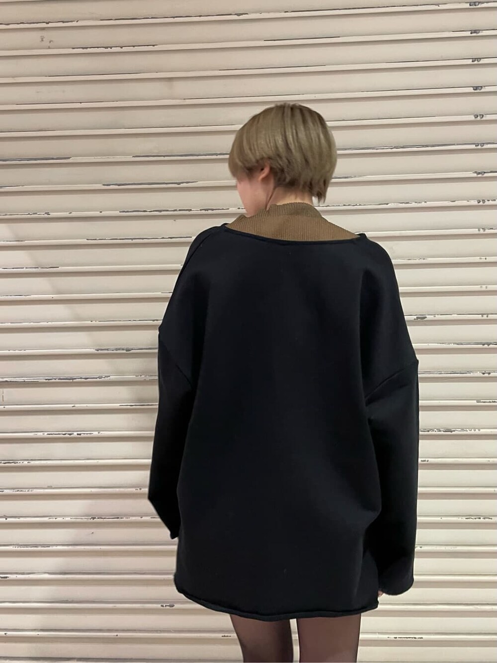 ブラック系のブーツ、ブラック系のスカート、ブラウン系のTシャツ/カットソーを着用したレディースの冬コーディネートの6枚目の写真