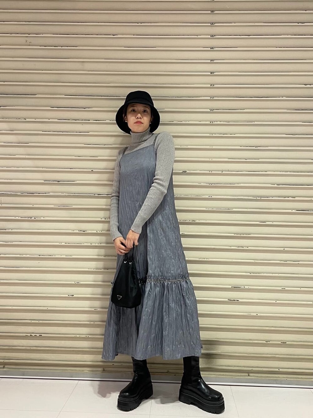 グレー系のニット/セーター、グレー系のワンピース、ブラック系のハットを着用したレディースの冬コーディネートの3枚目の写真