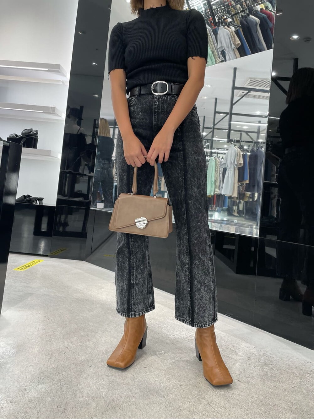 ブラウン系のブーツ、ブラウン系のハンドバッグ、ブラック系のニット/セーターを着用したレディースの夏コーディネートの2枚目の写真