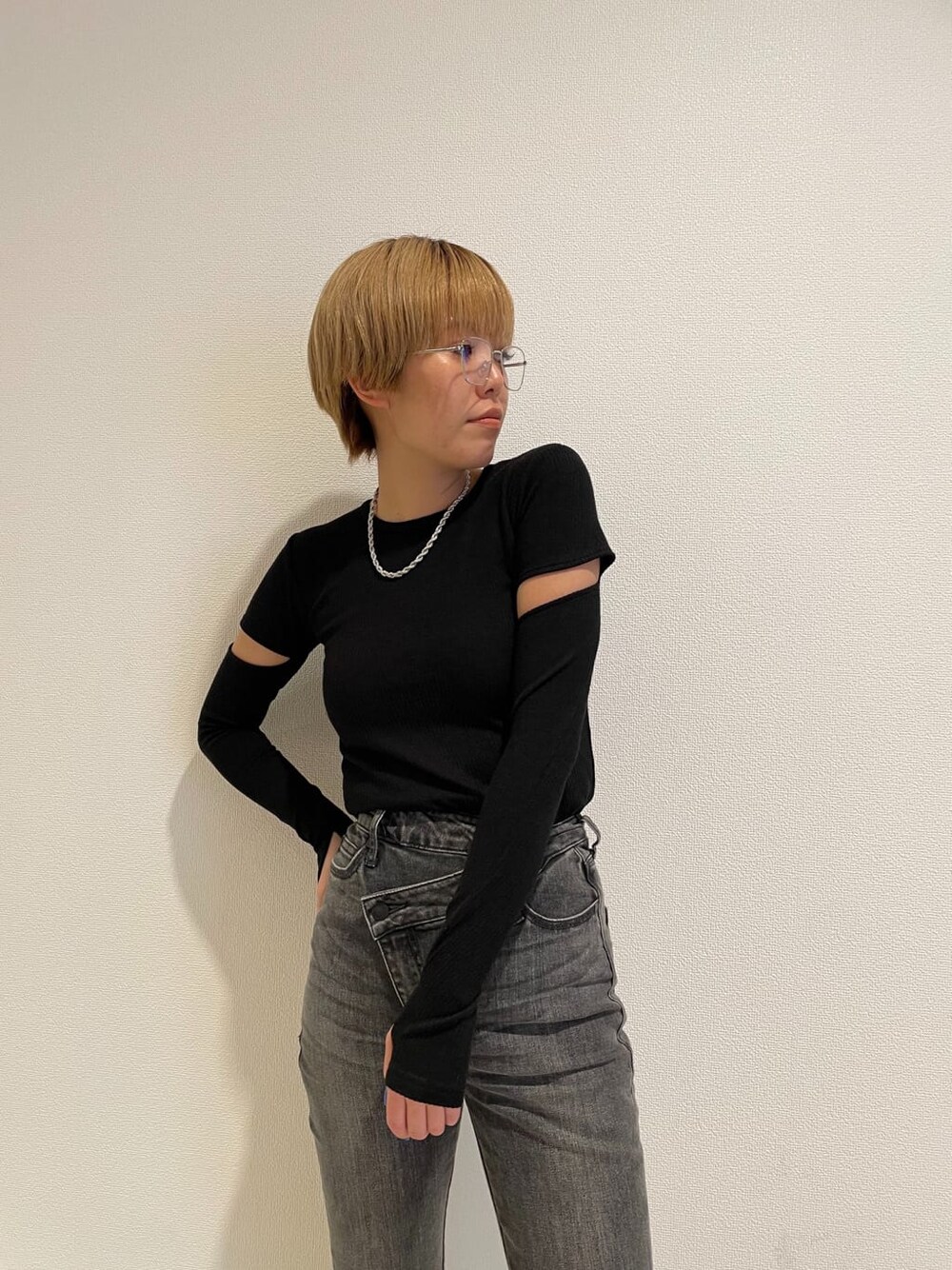 グレー系のデニムパンツ、ブラック系のTシャツ/カットソー、ブラック系のメガネを着用したレディースの春コーディネートの6枚目の写真