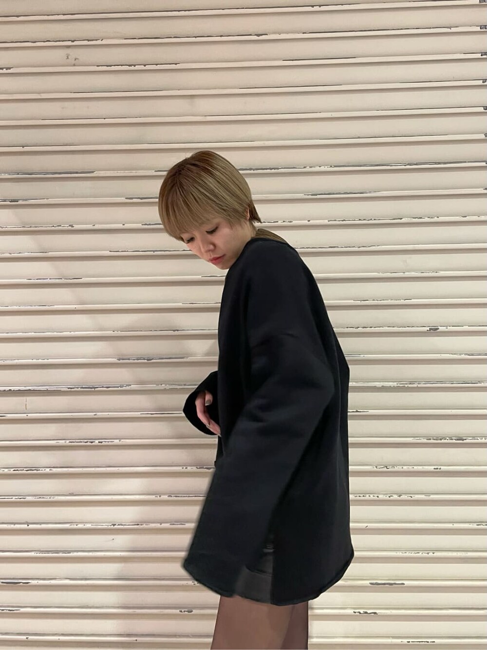 ブラック系のブーツ、ブラック系のスカート、ブラウン系のTシャツ/カットソーを着用したレディースの冬コーディネートの5枚目の写真