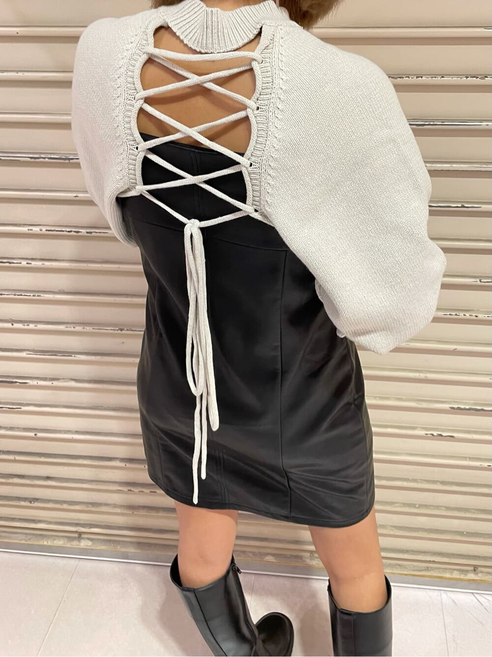 ブラック系のワンピース、ブラック系のブーツ、ホワイト系のニット/セーターを着用したレディースの秋コーディネートの6枚目の写真