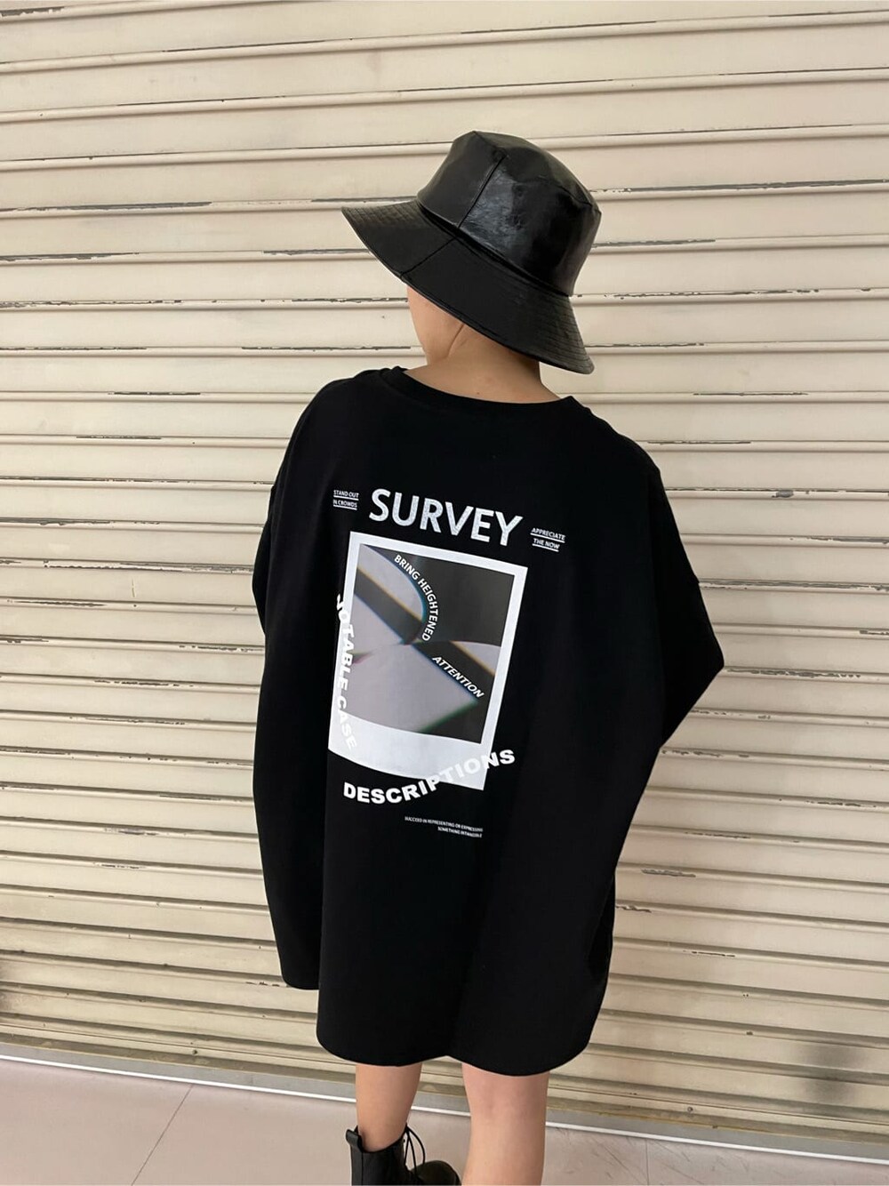ブラック系のブーツ、ブラック系のTシャツ/カットソー、ブラック系のハットを着用したレディースの冬コーディネートの6枚目の写真