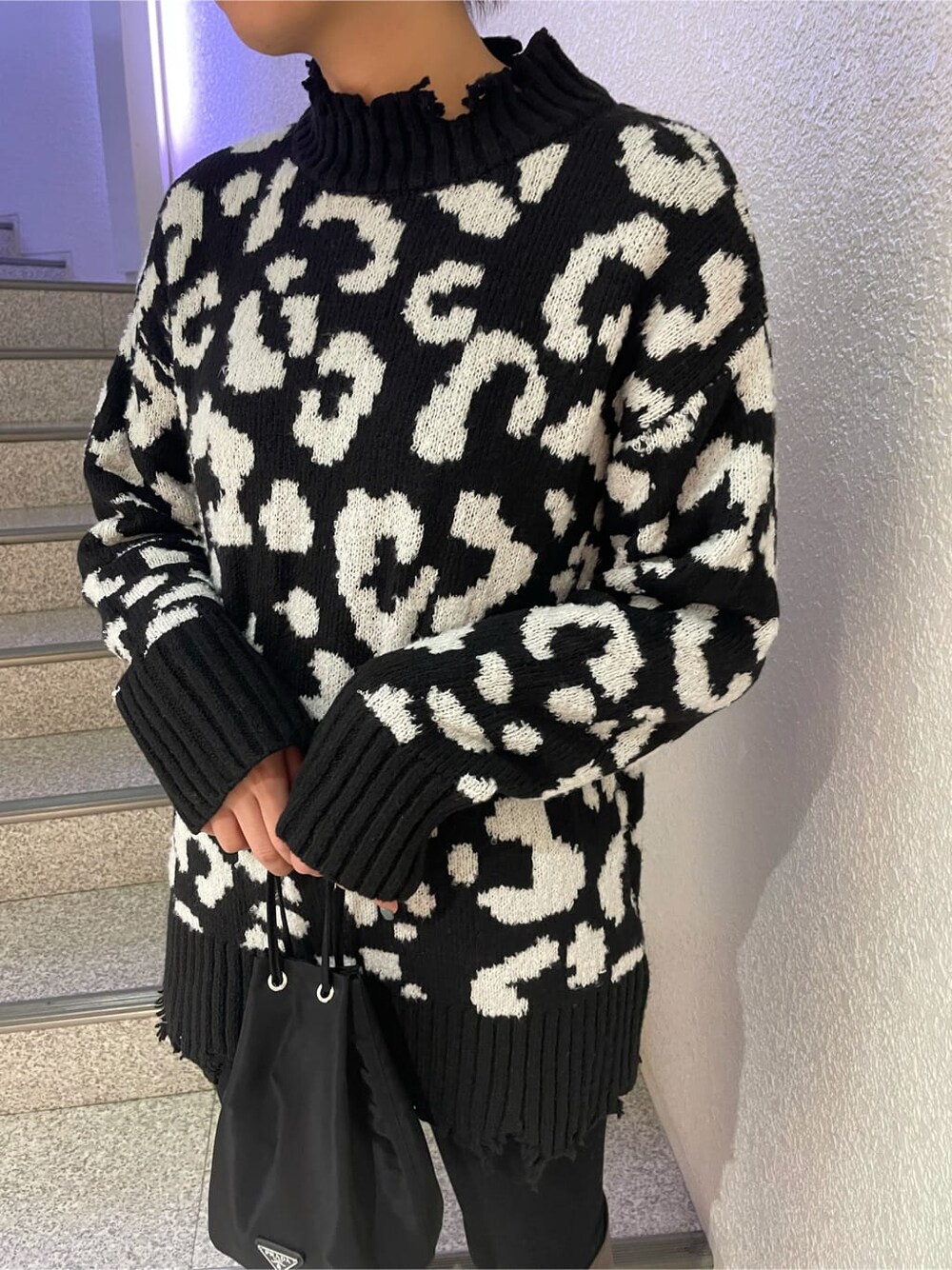 ブラック系のデニムパンツ、ブラウン系のブーツ、ブラック系のニット/セーターを着用したレディースの冬コーディネートの4枚目の写真