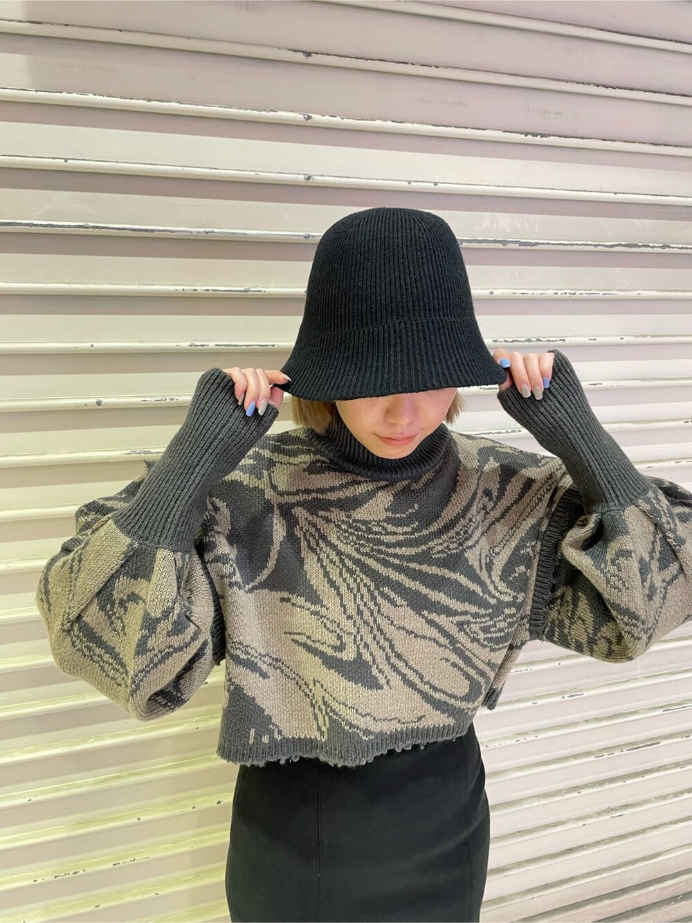 ブラック系のスカート、ブラック系のブーツ、その他のニット/セーターを着用したレディースの秋コーディネートの7枚目の写真