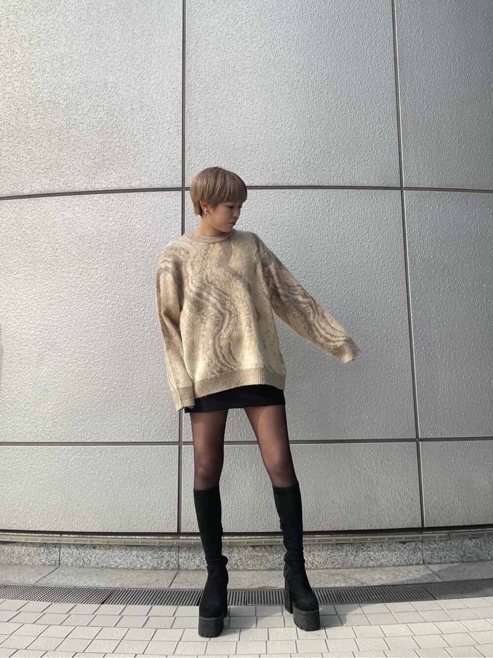 ベージュ系のニット/セーター、ブラック系のスカート、ブラック系のブーツを着用したレディースの冬コーディネートの2枚目の写真