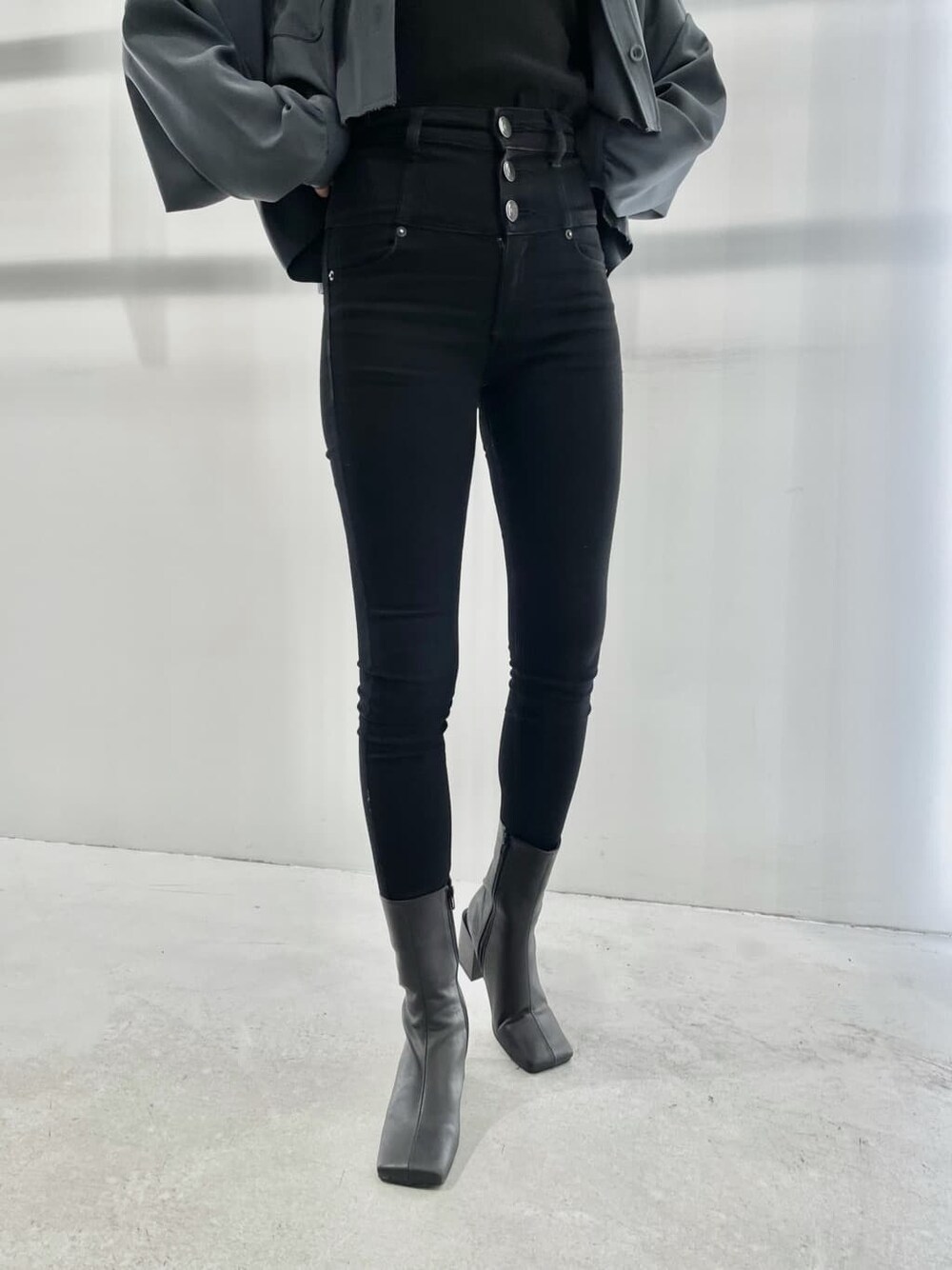 ブルー系のテーラードジャケット、ブラック系のブーツ、ブラック系のデニムパンツを着用したレディースの夏コーディネートの6枚目の写真