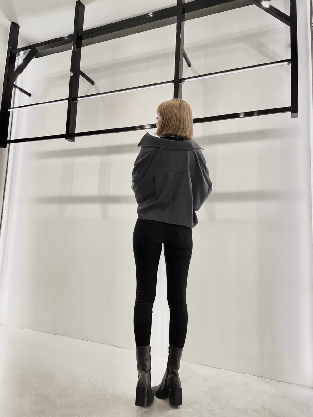 ブルー系のテーラードジャケット、ブラック系のブーツ、ブラック系のデニムパンツを着用したレディースの夏コーディネートの3枚目の写真